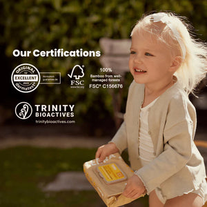 Child holding a product with certifications displayed on a blurred natural background